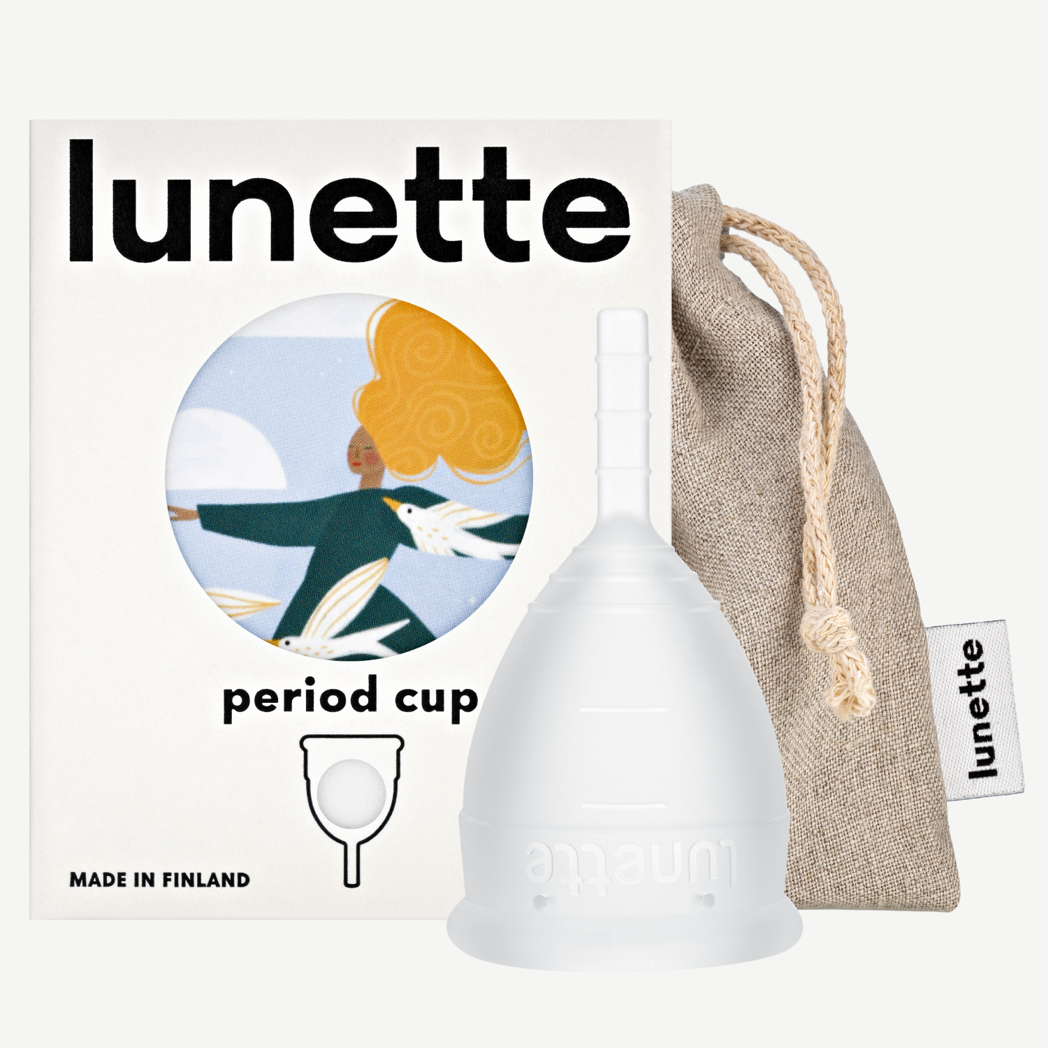 A white Lunette period cup displayed alongside its packaging box with a floral design and a linen storage pouch. The box includes the text 'period cup', 'made in Finland', and the brand name 'Lunette'.